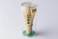 Bamboo chasen inside its clear plastic shipping case with a green base