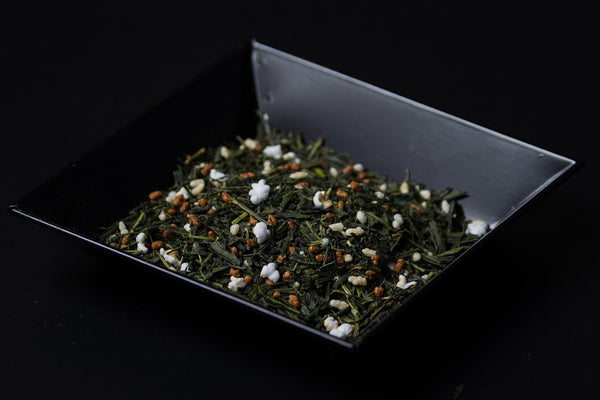 Black square box on black background containing Ippodo Tea Co. Genmaicha Japanese green tea mixed with golden toasted rice