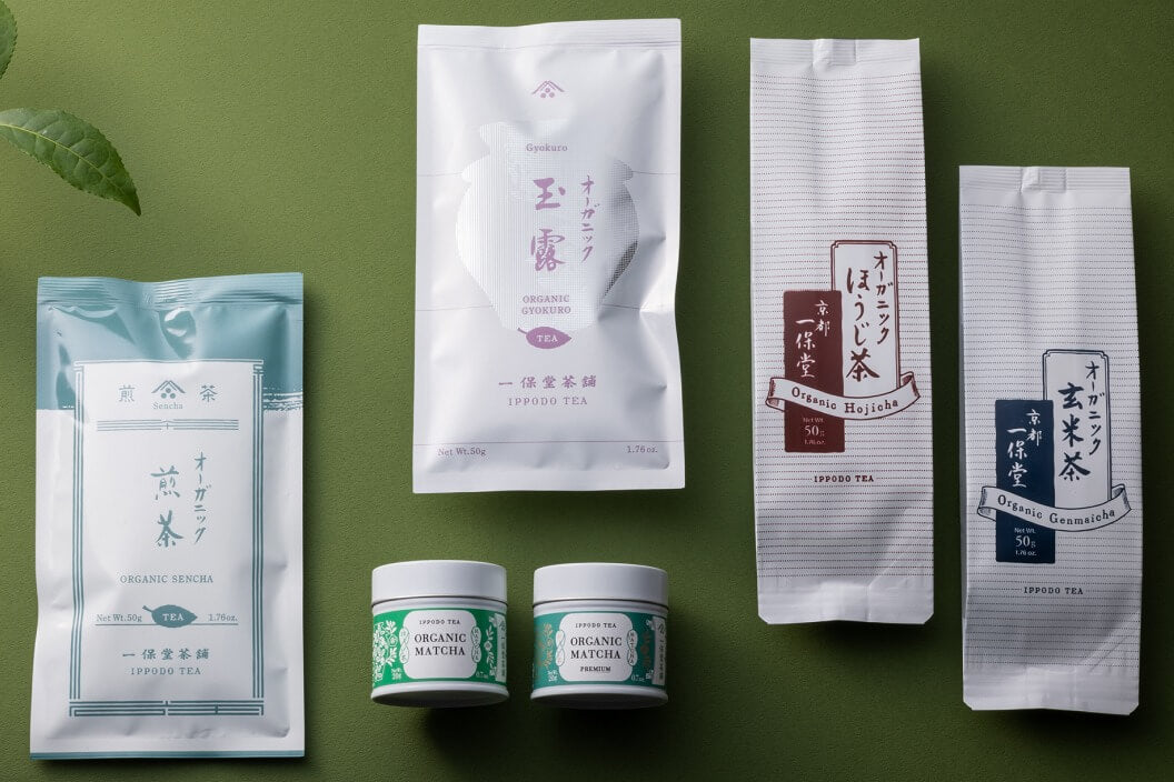 Picture of the ippodo tea organic selection of teas. Bags of organic sencha, gyokuro, hojicha, genmaicha and matcha on a green background