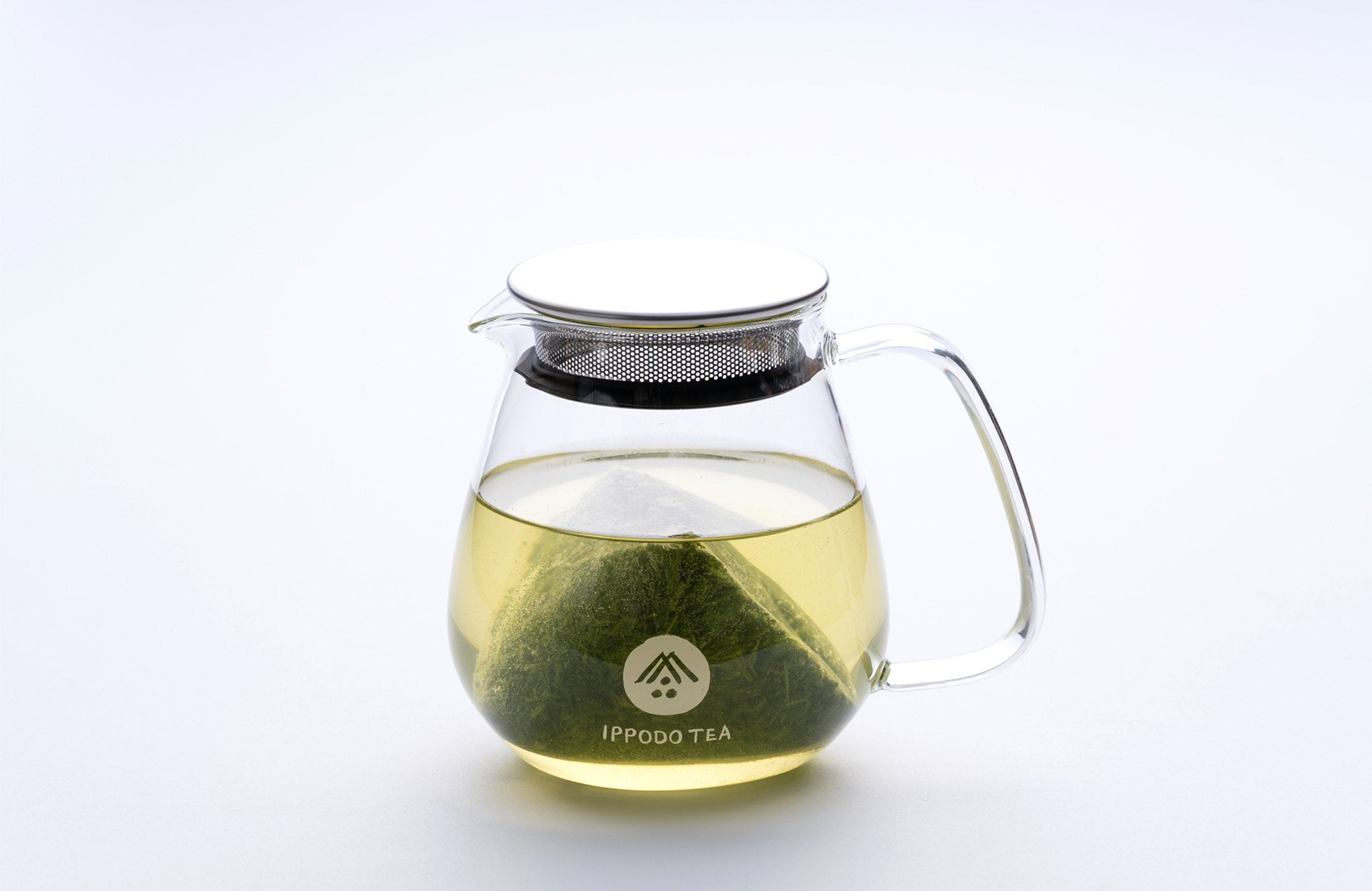 Gyokuro teabag in a glass teapot steeping in hot water.