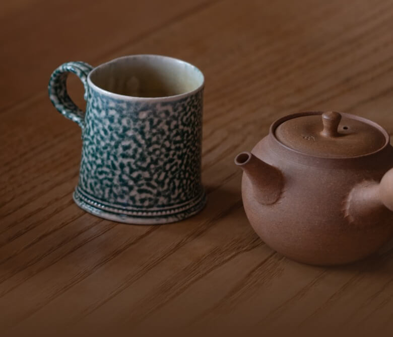 Hojicha 100g on a table with person reading a book