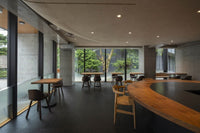 Front of of Ippodo Tea's flagship store, tearoom and headquarters black storefront in Kyoto, Japan with outdoor lit neon sign
