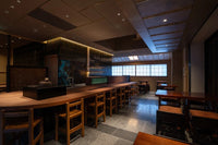 Front of of Ippodo Tea's flagship store, tearoom and headquarters black storefront in Kyoto, Japan with outdoor lit neon sign