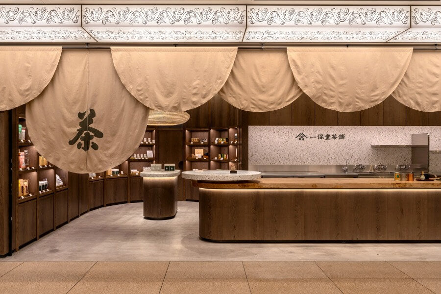 Front of of Ippodo Tea's flagship store, tearoom and headquarters black storefront in Kyoto, Japan with outdoor lit neon sign