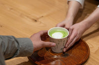 Front of of Ippodo Tea's flagship store, tearoom and headquarters black storefront in Kyoto, Japan with outdoor lit neon sign