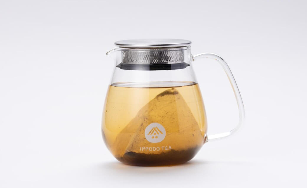 Mugicha Barley Teabag in a glass teapot steeping in hot water.